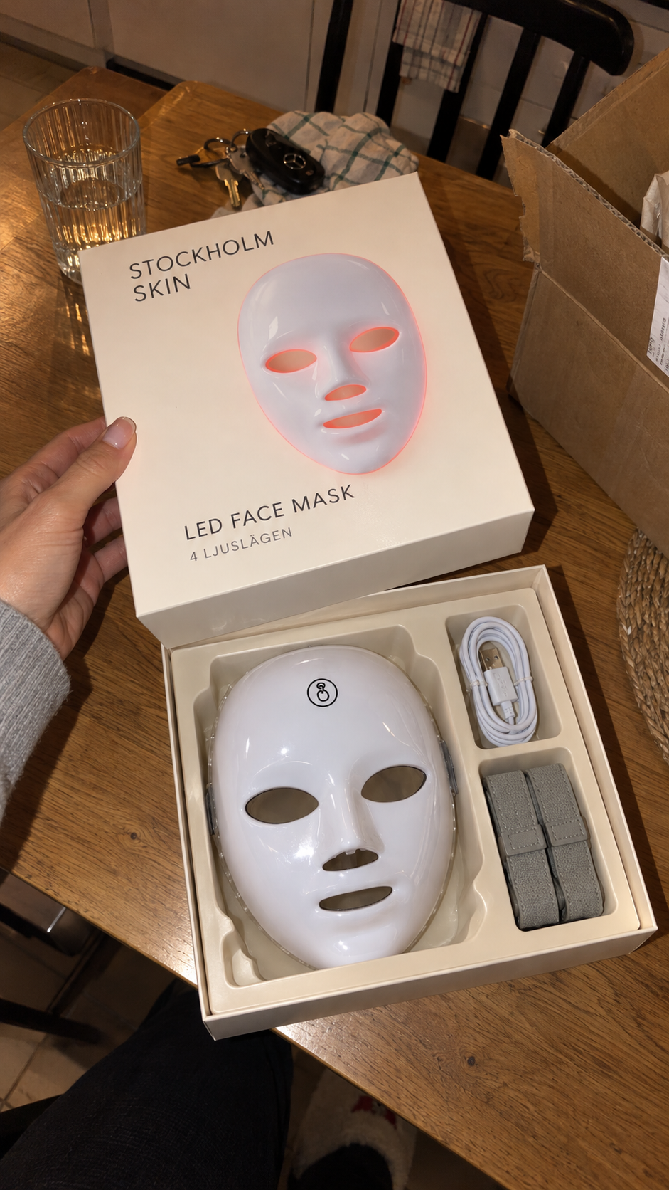 Förpackningen öppnad på ett köksbord med mask, sladd och band