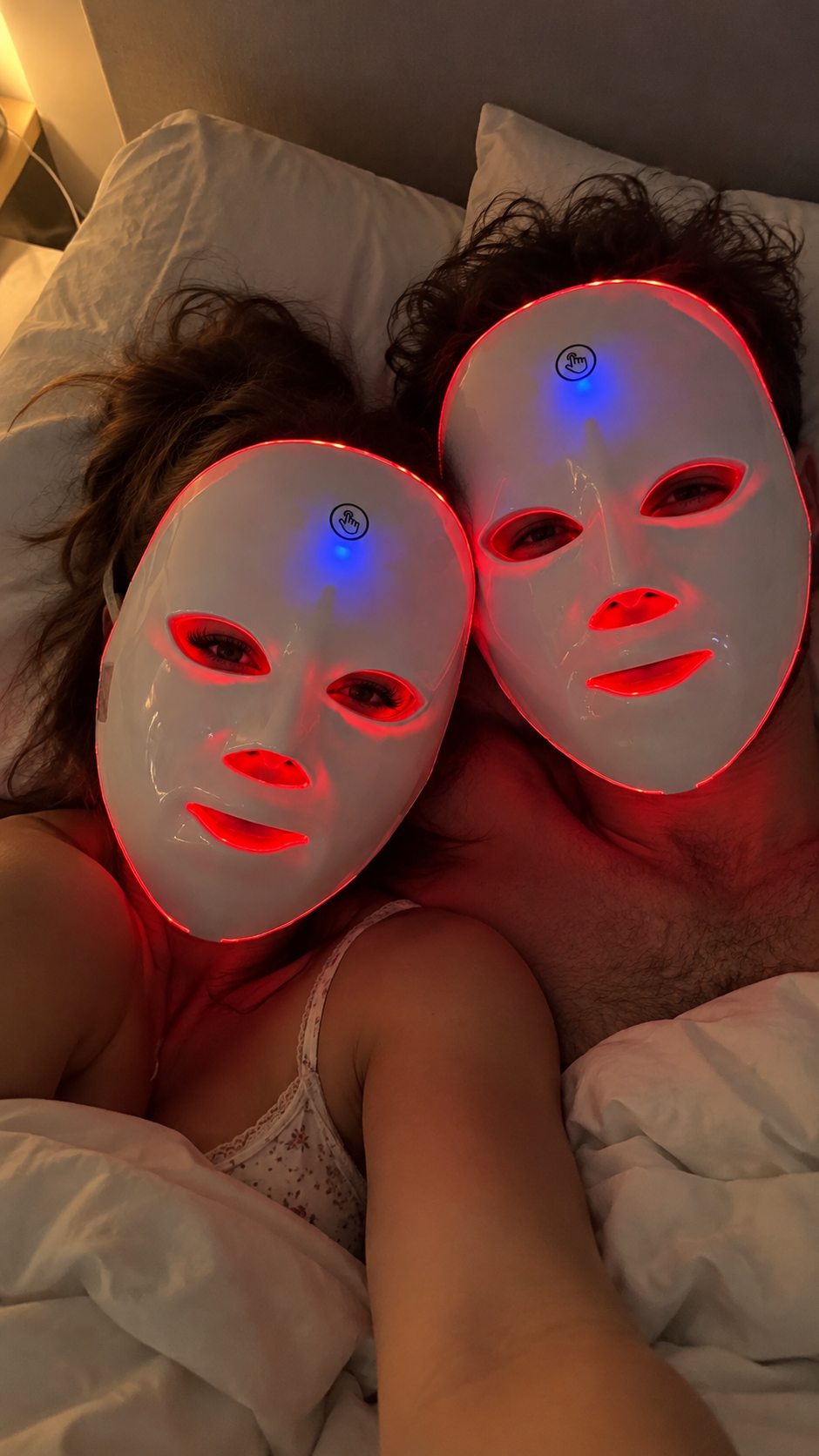 Ett par i sängen med varsin LED-mask